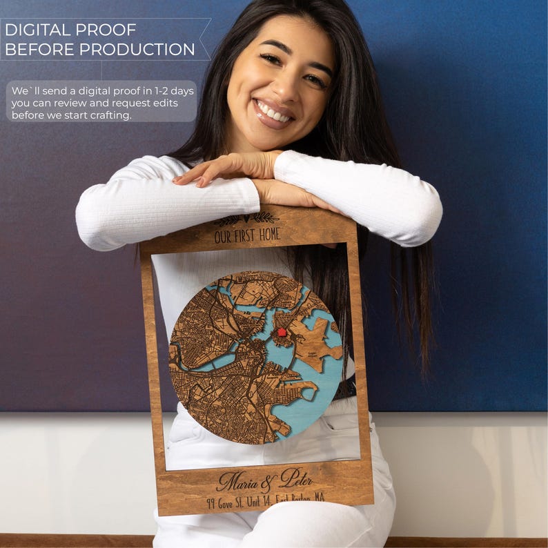 A smiling woman holds the framed custom map beside text about receiving a digital proof before production. This image reassures buyers that their first home gift can be reviewed and approved before it is made.