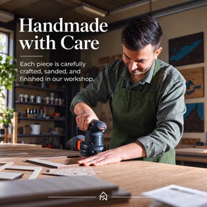 May include: A person wearing a green apron uses a black and orange power sander on a wooden frame. The text reads: Handmade with Care. Each piece is carefully crafted, sanded, and finished in our workshop. A small logo is at the bottom center.
