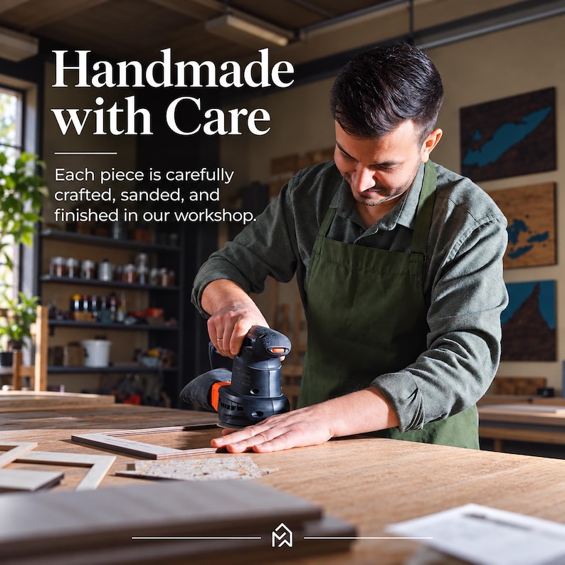 May include: A person wearing a green apron uses a black and orange power sander on a wooden frame. The text reads: Handmade with Care. Each piece is carefully crafted, sanded, and finished in our workshop. A small logo is at the bottom center.