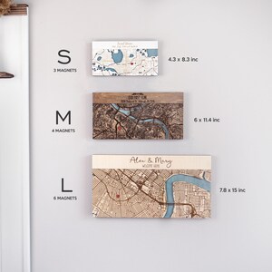 May include: Three sizes of wooden engraved maps with magnets. The smallest size is 4.3 by 8.3 inches, the medium size is 6 by 11.4 inches, and the largest size is 7.8 by 15 inches. Each map has a red dot marking a location. The text on the maps reads "Our First Home" and "Alex & Mary Welcome Home".