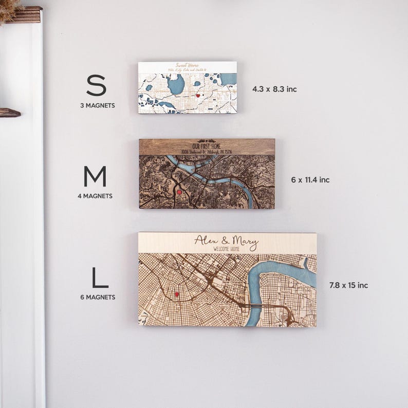 May include: Three sizes of wooden engraved maps with magnets. The smallest size is 4.3 by 8.3 inches, the medium size is 6 by 11.4 inches, and the largest size is 7.8 by 15 inches. Each map has a red dot marking a location. The text on the maps reads "Our First Home" and "Alex & Mary Welcome Home".