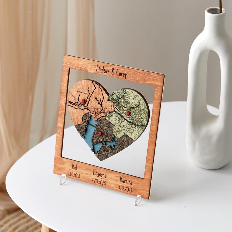 Custom locations puzzle map in a wooden frame, heart design with layered maps and red pins, personalized text—romantic couples anniversary gift.