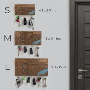 May include: Wooden key holders in three sizes: small (4.3 x 8.3 inches), medium (6 x 11.4 inches), and large (7.8 x 15 inches). Each features a map design with a blue river and the text "Collins Family". Keys and key fobs hang from the bottom.