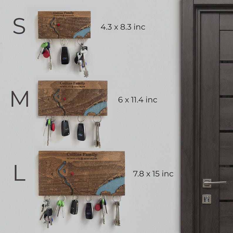 May include: Wooden key holders in three sizes: small (4.3 x 8.3 inches), medium (6 x 11.4 inches), and large (7.8 x 15 inches). Each features a map design with a blue river and the text "Collins Family". Keys and key fobs hang from the bottom.