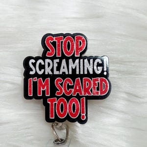 May include: A black and red glitter badge holder with the text "STOP SCREAMING! I'M SCARED TOO!"