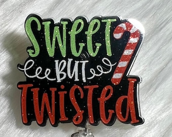 Op de afbeelding: Een zwarte en rode glitter badgehouder met een snoepstokontwerp en de tekst "Sweet But Twisted".