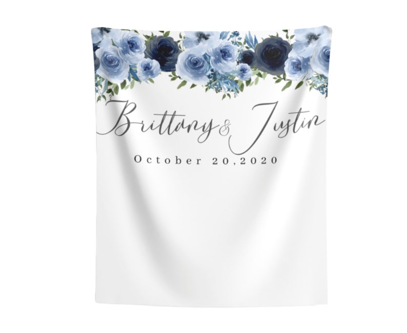 Pu&ograve; includere: Uno sfondo bianco con una ghirlanda di fiori blu in alto. Il testo "Brittany & Justin" &egrave; scritto in corsivo sotto la ghirlanda, seguito dalla data "October 20, 2020".