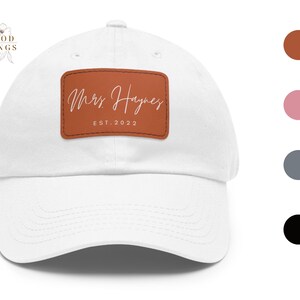 May include: White baseball cap with a brown leather patch that says "Mrs. Haynes Est. 2022".
