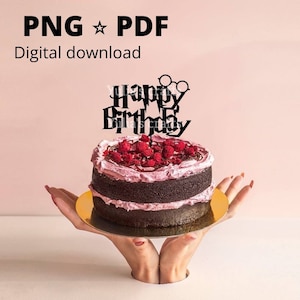 May include: Black cake topper with the words "Happy Birthday" and Harry Potter glasses on top of a chocolate cake with pink frosting and raspberries.