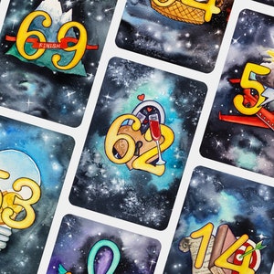 May include: A set of 10 colorful cards with a galaxy background. Each card features a different number in gold with a unique illustration. The numbers include 77, 69, 62, 57, 53, 52, 14, and 0. The card with the number 69 has the word "FINISH" written on it.