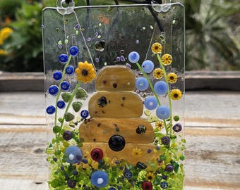 Beehive Fused Glass Suncatcher featuring purple, blue and yellow flowers and sunflowers. Adorable glass bees (4" x 6")