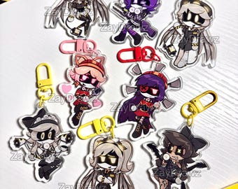 May include: A collection of eight acrylic keychains featuring stylized cartoon characters with robotic features, glowing eyes, and various outfits. Each charm includes a colorful plastic lobster clasp and the watermark text ZayDrawz printed on the surface.