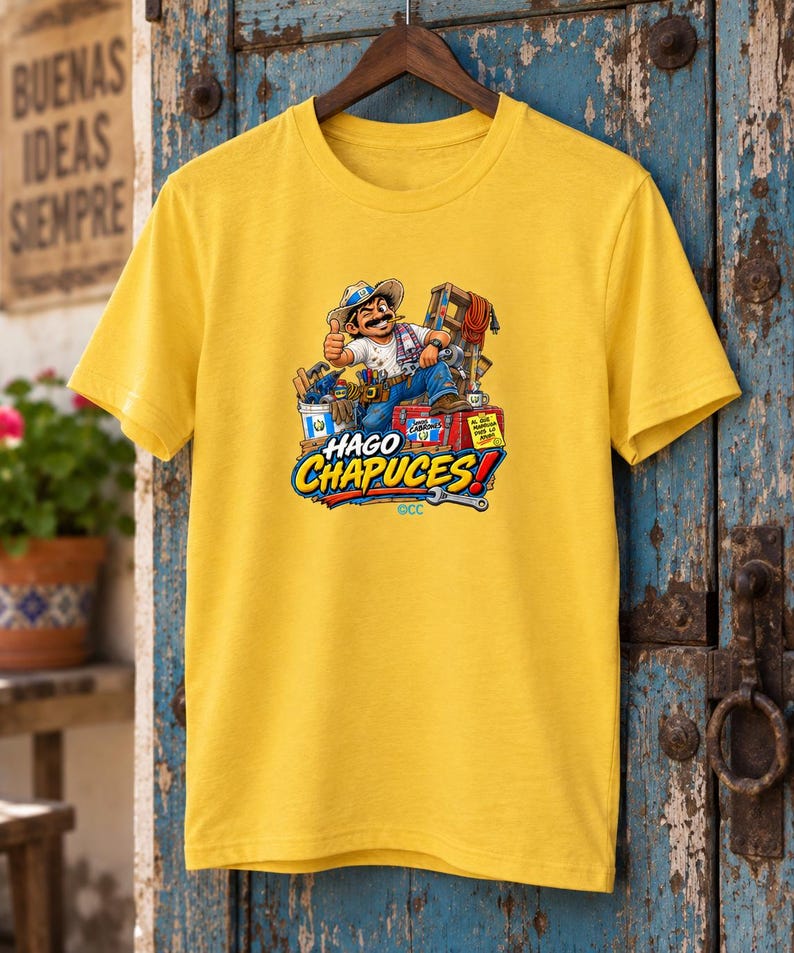 May include: A bright yellow short-sleeved t-shirt featuring a graphic illustration of a cartoon worker with a mustache and hat, surrounded by various tools and a red toolbox. The text HAGO CHAPUCES is printed in large blue and yellow letters below.