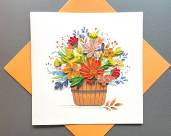 Könnte beinhalten: Eine handgemachte Grußkarte mit einem bunten Papierblumenstrauß in einem braunen Korb. Die Blumen sind aus Papier und in verschiedenen Farben angeordnet, darunter Rot, Orange, Gelb, Rosa und Blau.