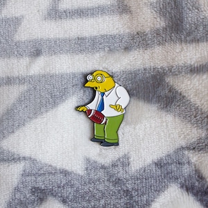 Hans Moleman Hit by Football Soft Enamel Pin