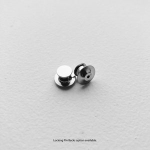 May include: Two silver locking pin backs for attaching a pin or badge to clothing.