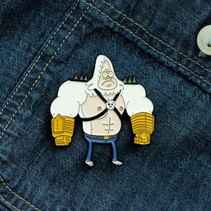 May include: A white and yellow enamel pin of a cartoon character with a white beard and a black harness. The character is wearing yellow gloves and has a serious expression.