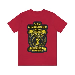 Op de afbeelding: Rood T-shirt met een geel grafisch ontwerp met de tekst "SCCM Administrator We Do Precision Guess Work Based On Unreliable Data Provided By Those Of Questionable Knowledge".