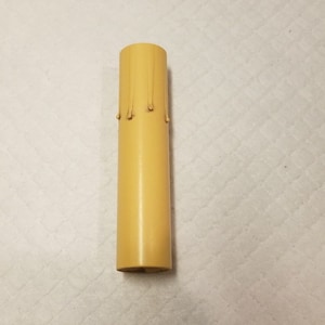 May include: A yellow candle with a drip design. The candle is about 6 inches tall and is made of wax.
