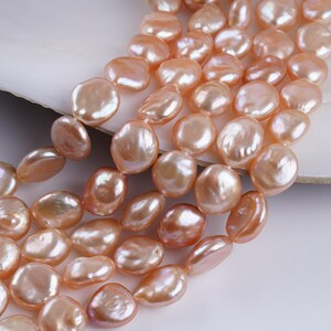 May include: Strands of lustrous, peach-colored freshwater pearls. The irregular, coin-shaped pearls have a smooth, iridescent surface. The pearls are strung together, creating a beautiful, natural jewelry element.