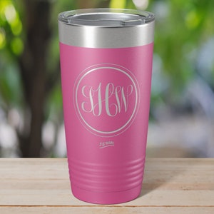 May include: A pink stainless steel tumbler with a white monogram "J.C.W." in a circle. The tumbler has a silver lid and a silver base.