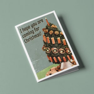 May include: A Christmas card with a humorous image of a Christmas tree made of hot dogs and other food items. The text on the card reads "I hope you are coming for Christmas!"