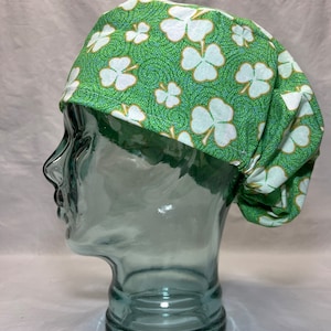 May include: Green and white surgical scrub hat with a shamrock pattern.