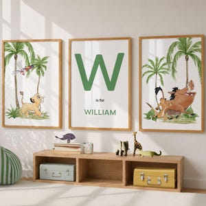 Puede incluir: Tres láminas decorativas enmarcadas con ilustraciones en acuarela de personajes de El Rey León. La lámina izquierda muestra un cachorro de león, la central muestra la letra W, el texto is for y el nombre WILLIAM, y la derecha muestra un cachorro de león y un jabalí.