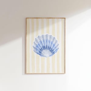 May include: A framed print of a blue seashell on a yellow and white striped background.