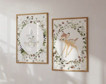 May include: Two framed prints with a white background and floral designs. The left print features a cartoon rabbit in a circle surrounded by flowers. The right print features a cartoon deer in a circle surrounded by flowers.