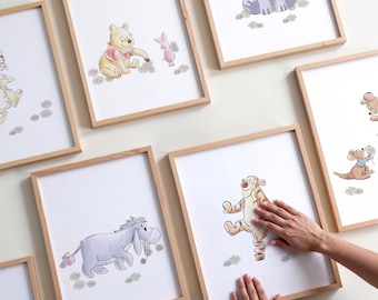 May include: A set of framed Winnie the Pooh character prints. Each print features a different character from the classic Disney cartoon, including Winnie the Pooh, Piglet, Eeyore, Tigger, and Roo. The prints are all in a white frame with a light wood finish.