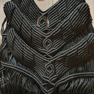 Puede incluir: Top negro de macram&eacute; con un patr&oacute;n geom&eacute;trico y detalles de flecos.