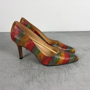 May include: A pair of high-heeled court shoes featuring a multi-coloured snakeskin-patterned texture in shades of red, orange, yellow, and green. The shoes have a pointed toe, a slim stiletto heel, and a tan interior lining with a visible size 37 stamp.