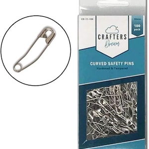 May include: A pack of 100 silver-coloured, 18mm curved safety pins. The package is labelled "Crafters Dream" and "Curved Safety Pins Hardened & Tempered".