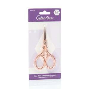 May include: Rose gold embroidery scissors with an ornate design, 9 cm long, packaged on a purple and white card with the text "The Quilted Bear" and "QB514-RG".