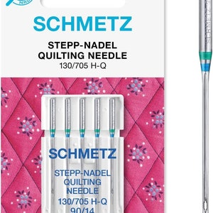 Op de afbeelding: Een verpakking met vijf zilveren quiltnaalden met blauwe en groene accenten. De naalden zijn ge&euml;tiketteerd met "Schmetz Stepp-Nadel Quilting Needle 130/705 H-Q 90/14".