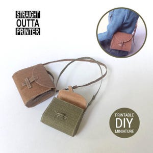 May include: Two miniature brown and olive green crossbody bags with long straps. One bag is open, revealing a light brown interior. The bags have a rectangular shape with a flap closure. The text "STRAIGHT OUTTA PRINTER" and "PRINTABLE DIY MINIATURE" are visible.