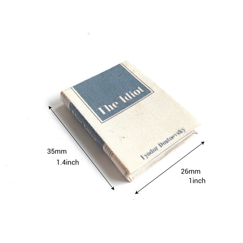 May include: A miniature book titled "The Idiot" by Fyodor Dostoevsky. The book is 1.4 inches tall and 1 inch wide.