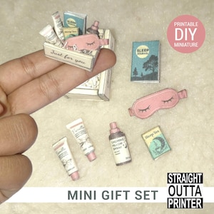 May include: Miniature sleep-themed gift set with a pink sleep mask, small books, and cosmetic tubes. The set includes a box with the text "Just for you" and a bottle of calming pillow spray. The words "Mini Gift Set" are also visible.