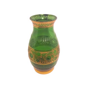 May include: A green glass vase with gold floral designs. The vase has a round body and a narrow neck.