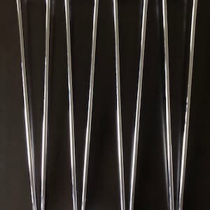 May include: Four silver metal hairpin table legs with a flat top plate. The legs are approximately 16 inches tall.