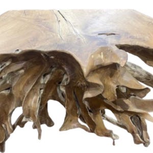 May include: A large, natural wood table base with a light brown finish. The table base has a flat top and a complex, root-like structure underneath, creating a unique and organic design. The wood grain is visible throughout the piece.