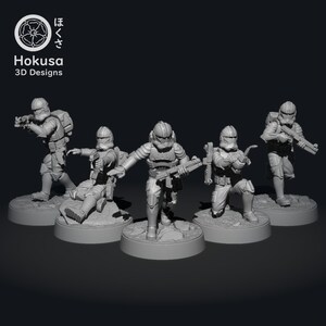 Może przedstawiać: Pięć szarych plastikowych figurek miniaturowych klonów żołnierzy z uniwersum Gwiezdnych Wojen. Figurki są w różnych pozach akcji i trzymają broń. Figurki stoją na małych szarych podstawkach.