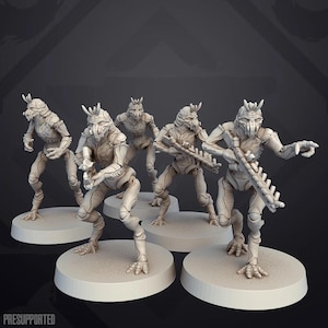 Könnte beinhalten: Fünf unbemalte, detaillierte Miniaturfiguren von humanoiden Kreaturen mit großen Köpfen und langen Gliedmaßen, die Waffen halten. Die Figuren stehen auf runden Sockeln.