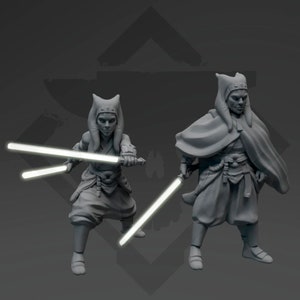 May include: Two grey painted figurines of Jedi warriors with lightsabers. The figures are posed in a fighting stance. The figures are wearing robes and have head coverings.