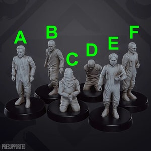 May include: Six miniature figures in various poses, wearing hooded jumpsuits and holding tools. The figures are painted in shades of grey and are standing on black bases.