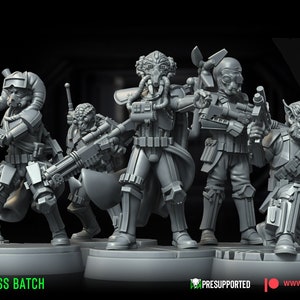 May include: A group of gray, detailed miniature figures, each holding weapons and wearing futuristic armor. The figures are on a circular base, with the text "THE BAD-ASS BATCH" and "WARBEAR STUDIOS" visible. The image is pre-supported.