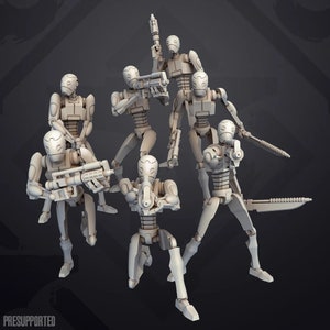 Op de afbeelding: Een set van zes ongeverfde, grijze plastic miniatuurfiguren van humanoïde robots die wapens vasthouden. De figuren zijn in verschillende actiehoudingsposes geposeerd.