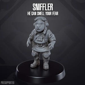 Op de afbeelding: Een grijs, gedetailleerd miniatuurfiguur van een wezen met een snuit, dat een helm en een gereedschapsriem draagt. Het figuur staat op een ronde basis. De tekst "SNIFFLER" en "HE CAN SMELL YOUR FEAR" staat boven het figuur.