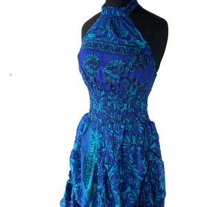 Puede incluir: Un vestido halter de estampado floral azul y verde con falda fruncida y un lazo en la parte inferior.